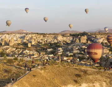 Mongolfiere in Cappadocia sopra valli con camini delle fate