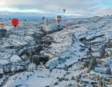 Mongolfiere in Cappadocia sopra valli con camini delle fate