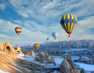 Mongolfiere in Cappadocia sopra valli con camini delle fate