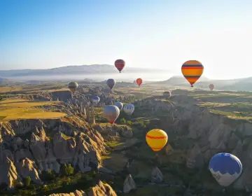 Sunrise balloons flying over valley fairy chimneys