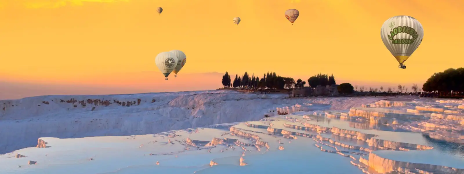 Hot air balloons flying over Pamukkale travertine terraces