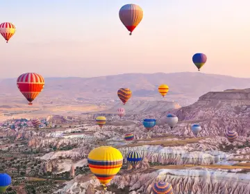 Mongolfiere in Cappadocia sopra le valli al tramonto