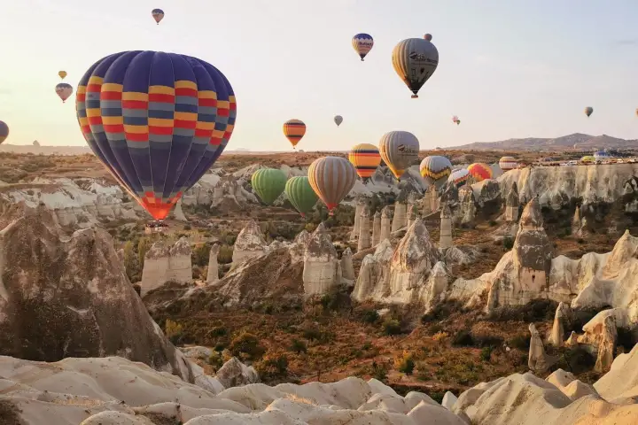 Balloons flying over fairy chimneys in valley