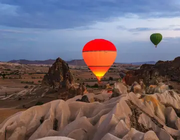 Winter sunrise with balloons over snowy rocks