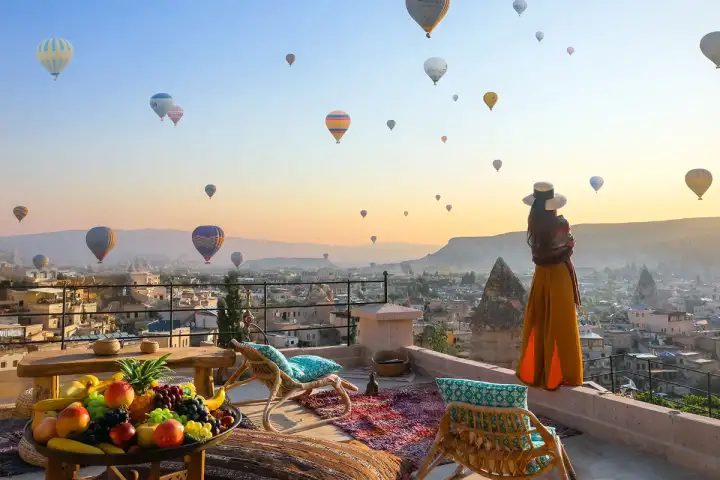 Terrace breakfast table at sunrise with hot air balloons