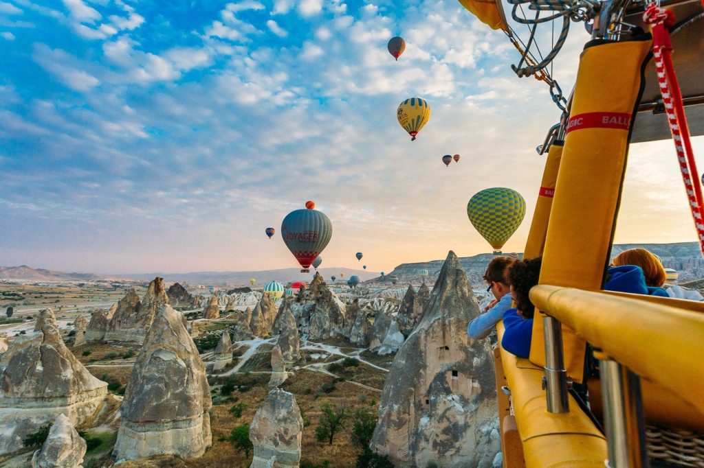 Panoramic view of hundreds of hot air balloons floating above Göreme National Park