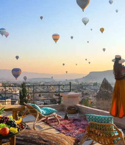 Terrace breakfast table at sunrise with hot air balloons