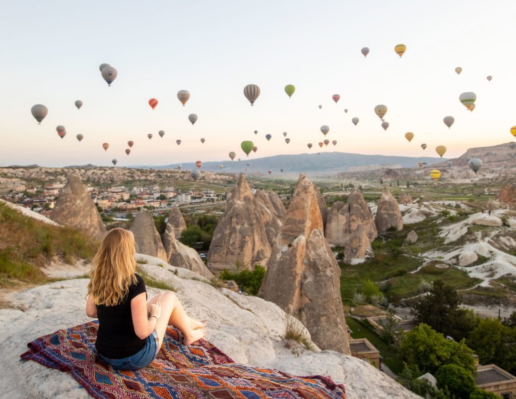 Picnic on cliff with sunrise view of hot air balloons