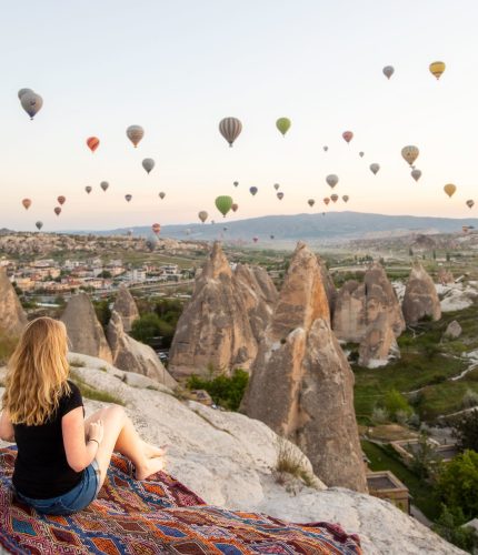 Picnic on cliff with sunrise view of hot air balloons