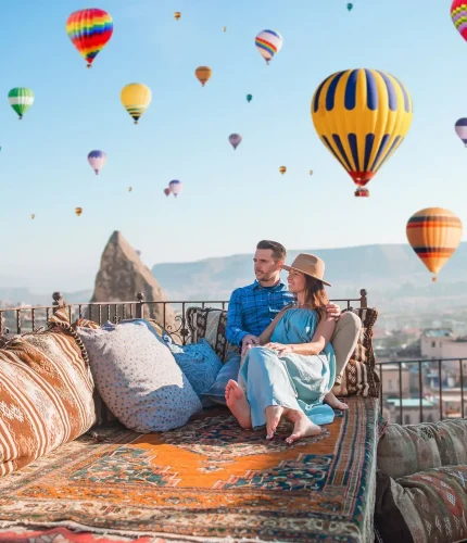 Couple on terrace viewing fairy chimneys and balloons