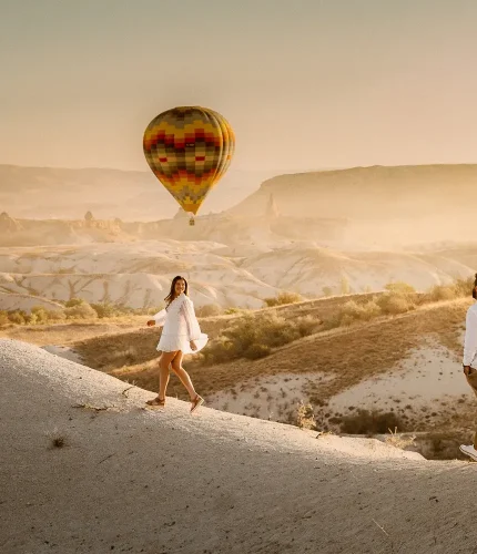 Couple walking at sunrise in balloon landscape