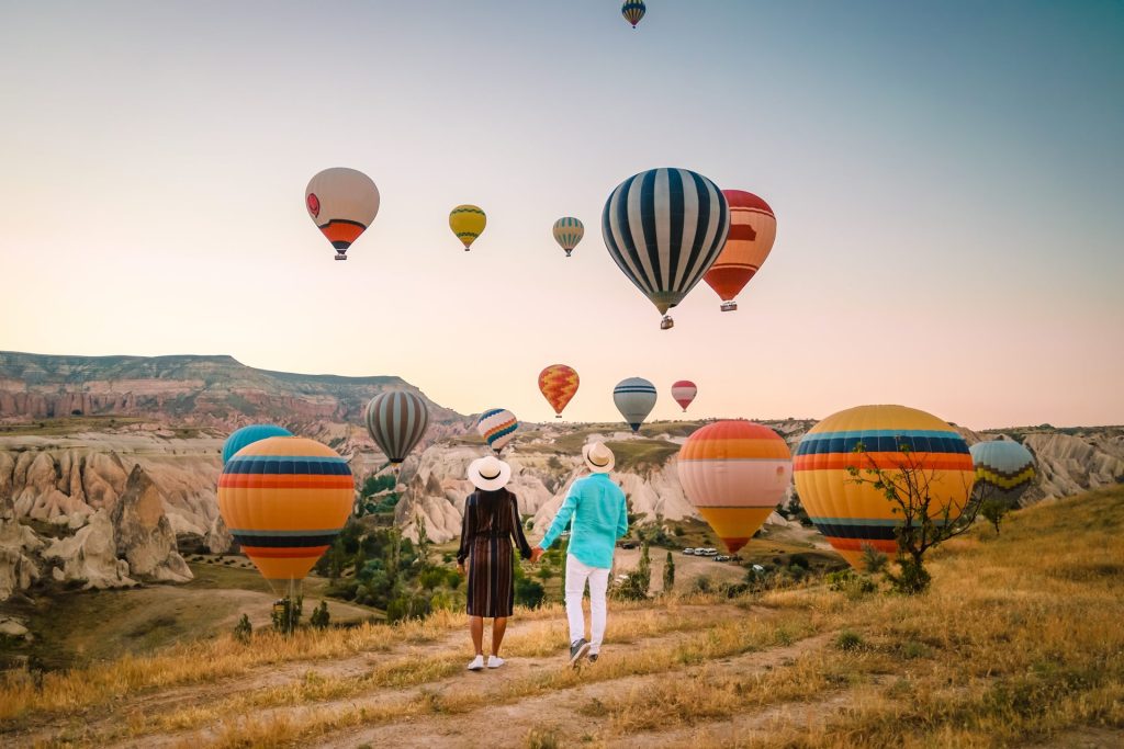 Family with child watching hot air balloons in field