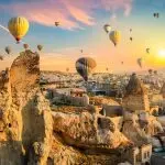 Goreme panorama at sunset with hot air balloons