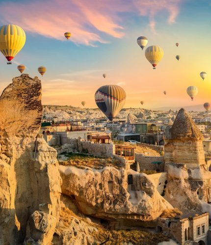 Goreme panorama at sunset with hot air balloons