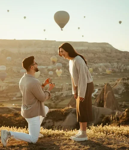 Marriage proposal at sunset with hot air balloons