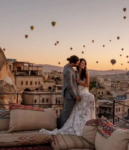 Wedding couple on rooftop at sunset with balloons