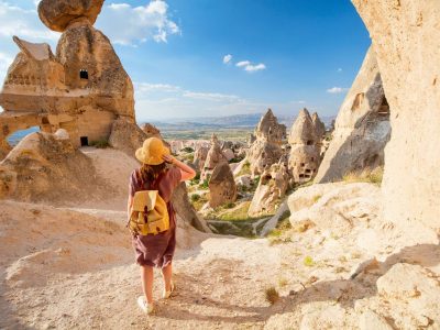 Back view of solo female traveler hiking fairy chimneys