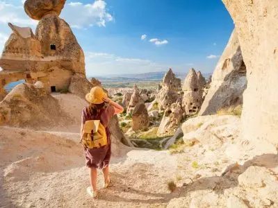 Back view of solo female traveler hiking fairy chimneys