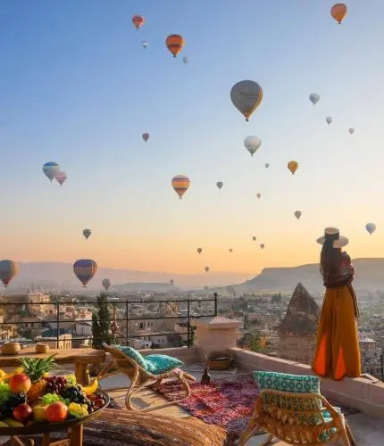 Terrace breakfast spread with sunrise hot air balloons