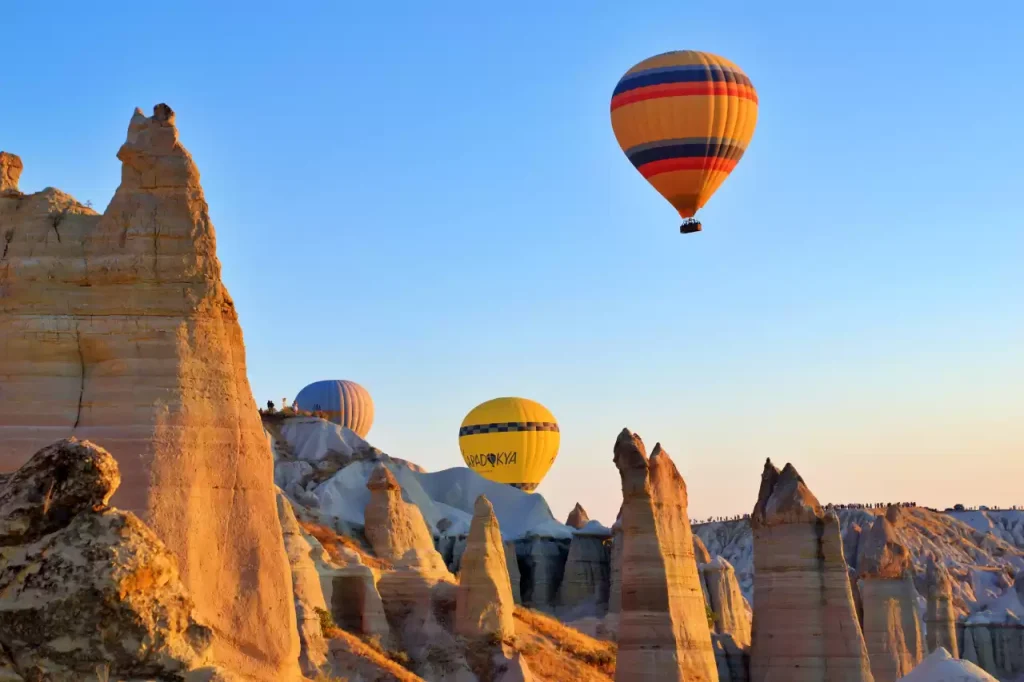 Hot air balloons flying over fairy chimneys in Cappadocia.