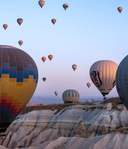 Sunrise view of balloons over Cappadocia ridge