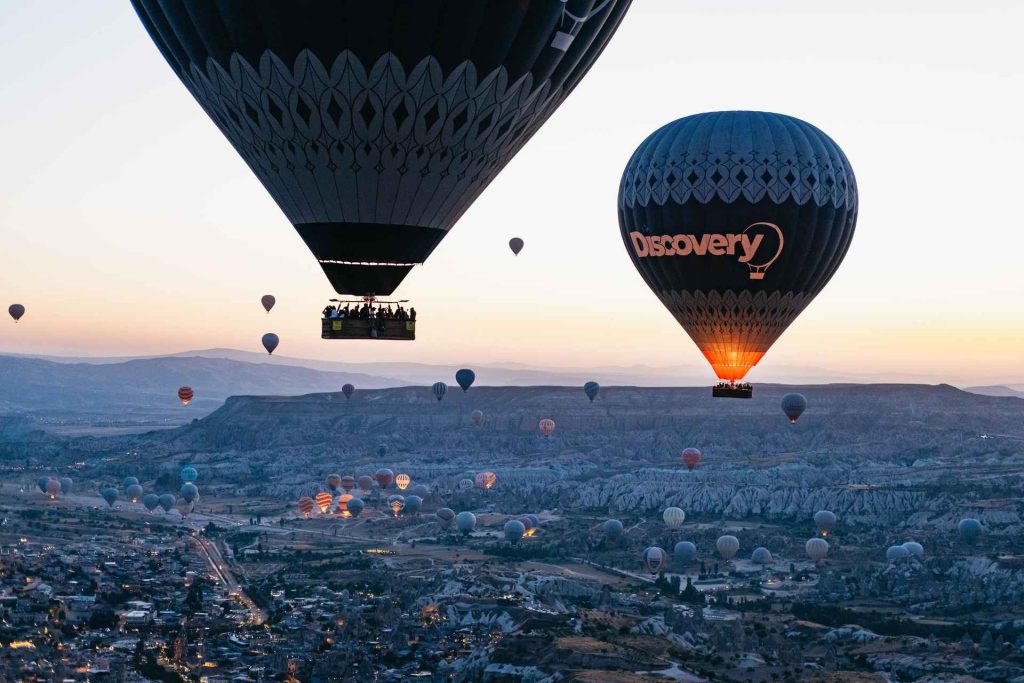 Balloons flying across Cappadocia at sunrise