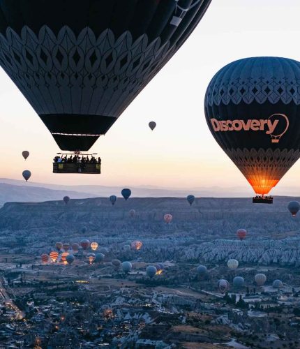 Balloons flying across Cappadocia at sunrise
