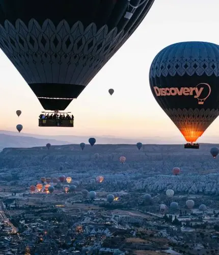 Balloons flying across Cappadocia at sunrise