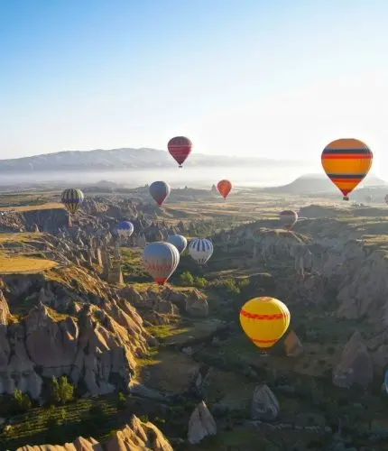 Sunrise balloons flying over valley fairy chimneys