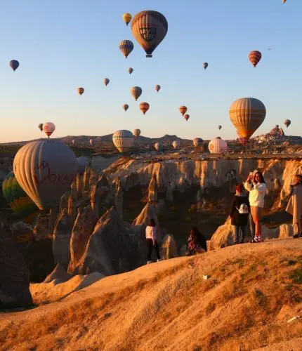 Warm evening light with balloons over Cappadocia