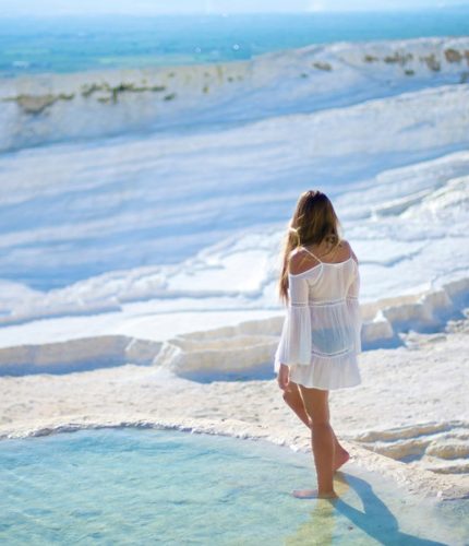 Woman walking on Pamukkale white terraces panorama